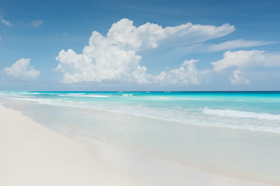 Pristine white sand beach with turquoise water representing the calm clarity of good saving habits