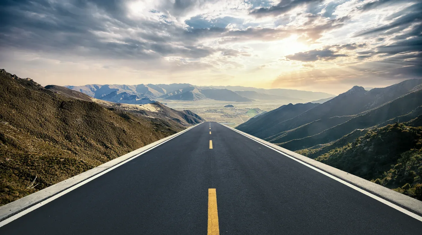 Open road through mountains leading toward the horizon